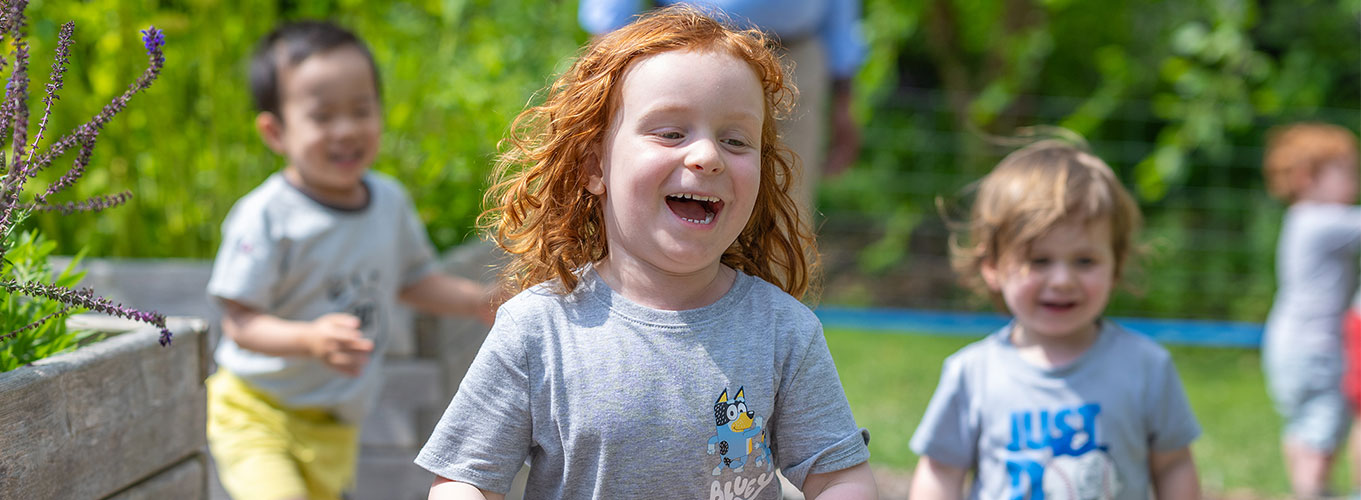 Children at the Holway Childhood Centers running though a garden